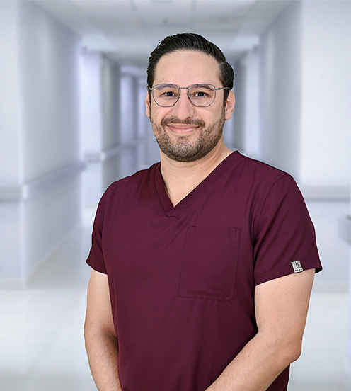 Es la foto de perfil de un otorrinolaringólogo en Ciudad Juárez de Hospital Angeles Ciudad Juárez. Tiene una camisa azul, bata blanca y corbata. Usa lentes.