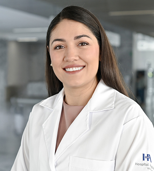 Es la foto de perfil de una especialista en terapia física en Querétaro de Hospital Angeles Centro-sur. Usa una blusa rosa claro y una bata blanca. Tiene el cabello largo y lacio color café.