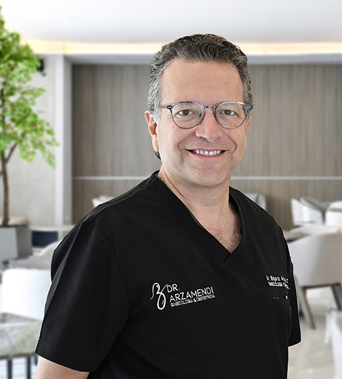 Es la foto de perfil de un ginecólogo y obstetra en San Pedro Garza de Hospital Angeles Valle Oriente. Usa un traje color negro con una camisa blanca y una corbata gris. Usa lentes. Tiene el cabello negro.