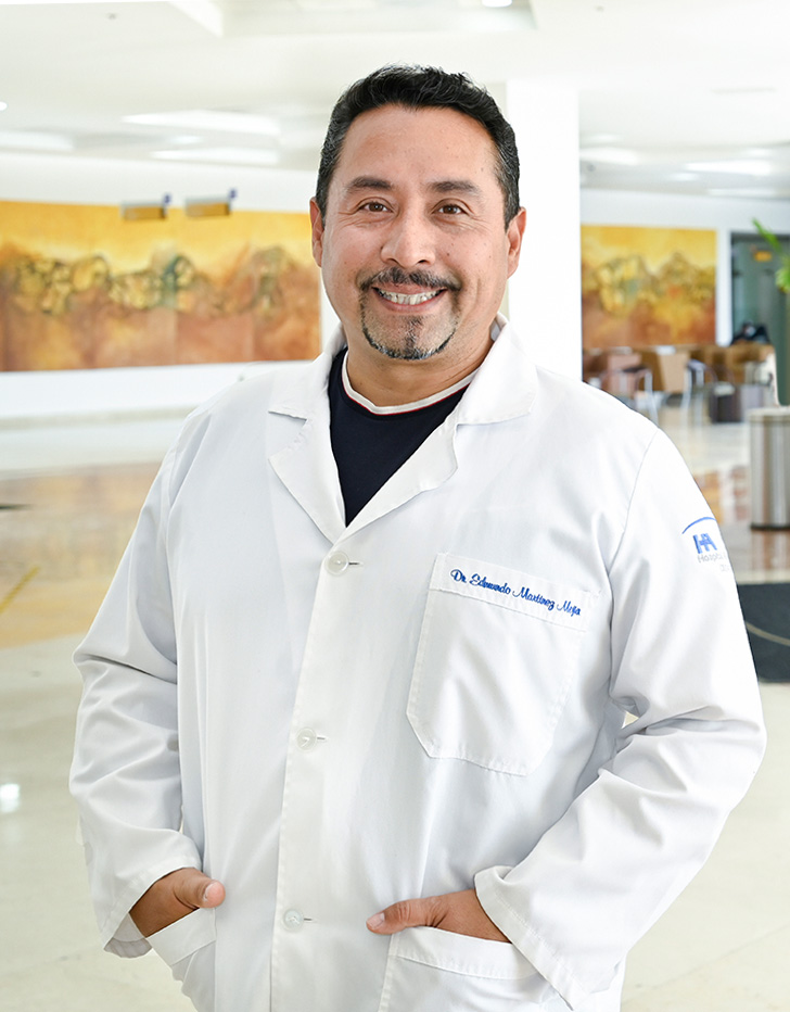 Es la foto de perfil de un ortopedista y traumatólogo en Ciudad Juárez de Hospital Angeles Ciudad Juárez. Usa una bata blanca y una playera negra con cuello blanco.