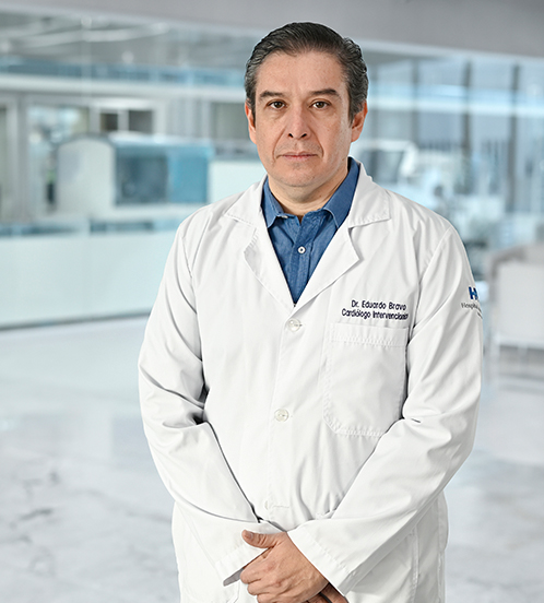 Es la foto de perfil de un cardiólogo intervencionista en Guadalajara de Hospital Angeles Del Carmen. Utiliza una bata blanca, camisa azul marino y cuadros blancos.
