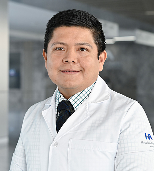 Es la foto de perfil de un ginecólogo y obstetra en Querétaro de Hospital Angeles Centro Sur. Viste una camisa azul marino con franjas blancas y rojas, formando cuadros.