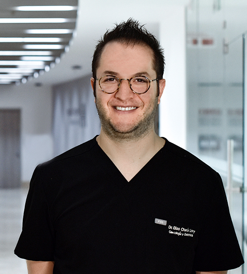 Es la foto de perfil de un ginecólogo y obstetra en Huixquilucan de Hospital Angeles Lomas. Usa un uniforme negro, está sonriendo, tiene cabello corto y usa lentes.