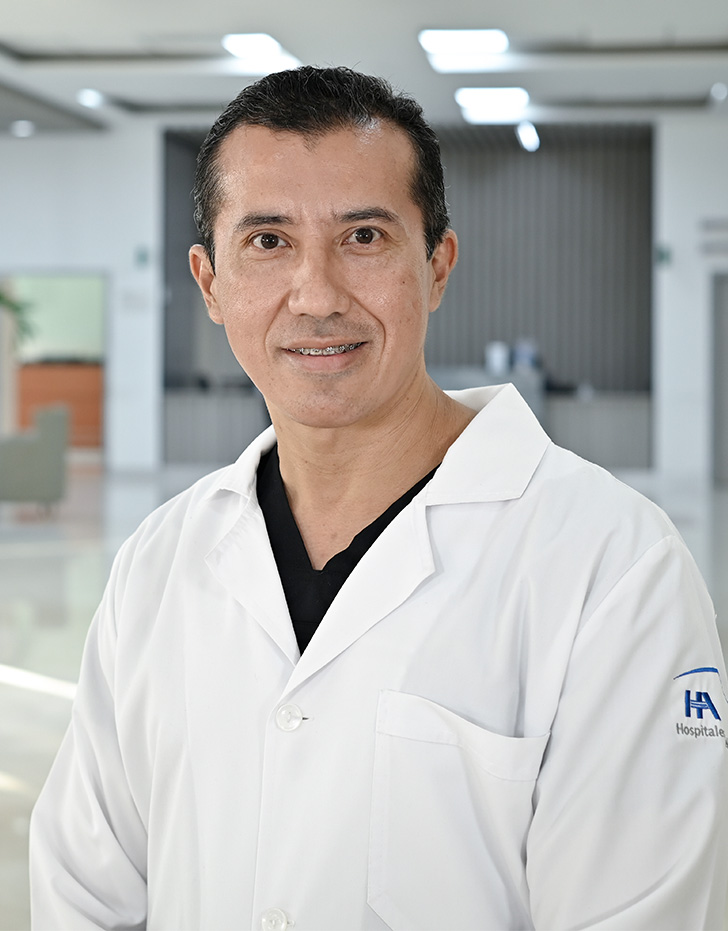 Es la foto de perfil de un infectólogo en Tampico de Hospital Angeles Tampico. Usa una bata blanca y un uniforme médico negro. Tiene el cabello negro. Está sonriendo.