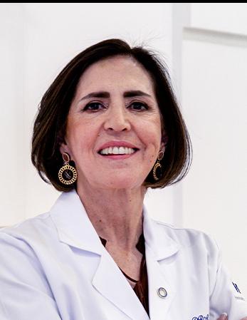 Es la foto de perfil de una oftalmóloga en León de Hospital Angeles León. Utiliza una bata blanca, una blusa negra y tiene el cabello negro, está sonriendo y usa aretes dorados con negro.