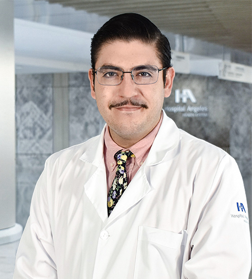 Es la foto de perfil de un psiquiatra en Querétaro de Hospital Angeles Centro-sur. Usa una bata blanca con una camisa color anaranjada claro y una corbata. Tiene el cabello y bigote café oscuro.