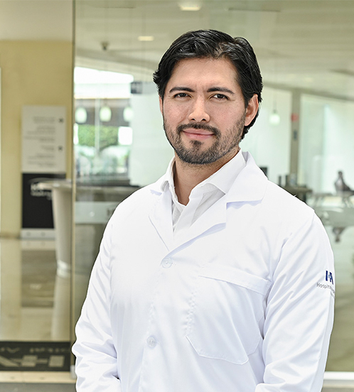 Es la foto de perfil de un cardiólogo en Ciudad de México de Hospital Angeles. Usa una bata blanca y una camisa blanca. Tiene el cabello negro ondulado.