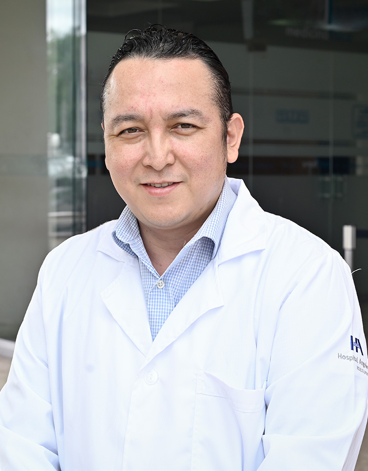 Es la foto de perfil de un neurólogo y neurofidiólogo en Villahermosa de Hospital Angeles Villahermosa. Usa una bata blnca y una camisa azul claro. Está sonriendo y tiene el cabello negro.