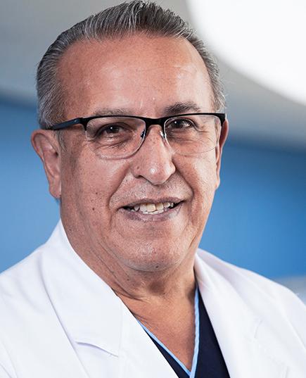 Es la foto de perfil de un ortopedista y traumatólogo en Huixquilucan de Hospital Angeles Lomas. Usa una bata blanca, playera negra, lentes negros, es de tez morena, cabello corto y canoso.