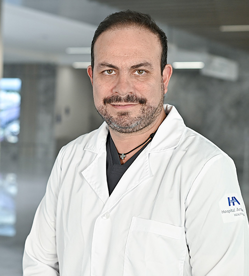 Es la foto de perfil de un urólogo en Querétaro de Hospital Angeles Centro Sur. Usa un uniforme negro y un collar negro con dorado.