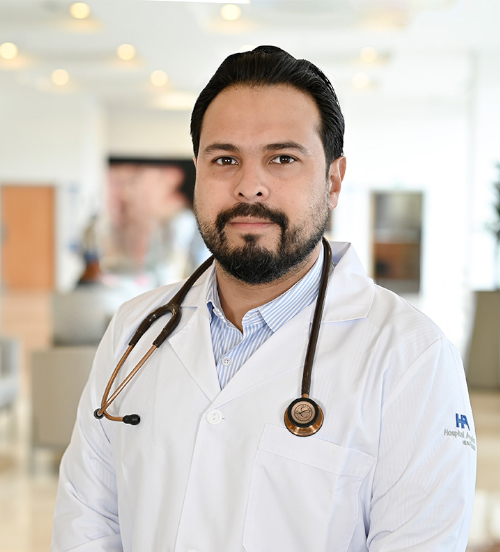 Médico Internista posa con bata blanca y estetoscopio dentro de las instalaciones de Hospital Angeles Xalapa.