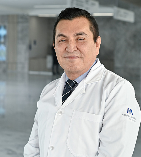Es la foto de perfil de un cirujano plástico y especialista en cirugía de manos en Querétaro de Hospital Angeles Centro Sur. Está sonriendo ligeramente, usa saco y chaleco negro de vestir, camisa blanca y corbata morada con negro y rayas blancas. 