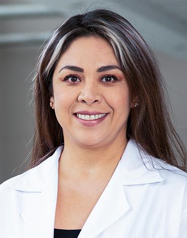 Es la foto de perfil de una psicóloga en Huixquilucan de Hospital Angeles Lomas. Usa una bata blanca con blusa negra y está sonriendo. 