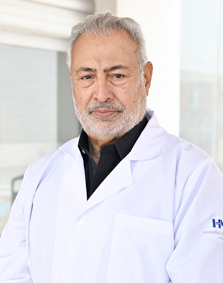 Es la foto de perfil de un pediatra en Tijuana de Hospital Angeles Tijuana. Usa un saco negro con un pañuelo rojo, una camisa blanca y una corbata amarilla. Tiene el cabello gris.