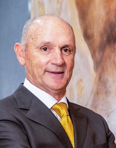 Es la foto de perfil de un ortodoncista en León de Hospital Angeles León. Usa un saco negro con camisa blanca, corbata amarrilla y está sonriendo.