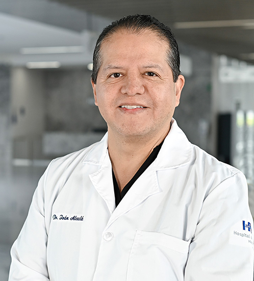 Es la foto de perfil de un cirujano oncológico en Querétaro de Hospital Angeles Centro Sur. Viste una camisa blanca con cuadros azul claro y está sonriendo.