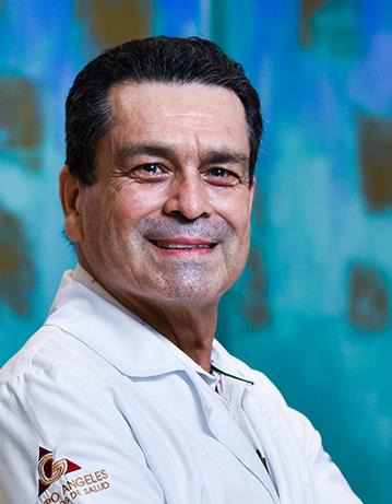 Es la foto de perfil de un pediatra en Villahermosa de Hospital Angeles Villahermosa. Usa una bata blanca. Tiene el cabello negro. Está sonriendo y tiene los brazos cruzados.