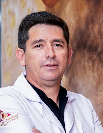 Es la foto de perfil de un cirujano neurológico en León de Hospital Angeles León. Usa una bata blanca con una camisa negra.