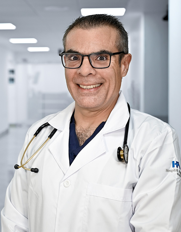 Es la foto de perfil de un cirujano general especialista en gastrocirugía en Guadalajara de Hospital Angeles Del Carmen. Utiliza una bata blanca, camisa blanca y corbata roja. 