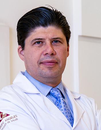 Es la foto de perfil de un cardiólogo en León de Hospital Angeles León. Usa una bata blanca con una camisa azul cielo y una corbata.