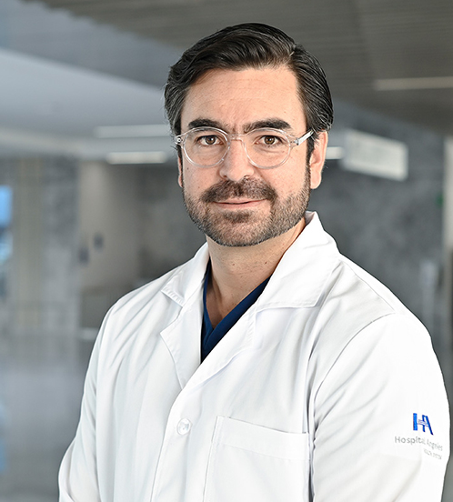 Es la foto de perfil de un ortopedista y traumatólogo en Querétaro de Hospital Angeles Centro Sur. Viste un uniforme azul, con cejas pobladas y barba oscura.