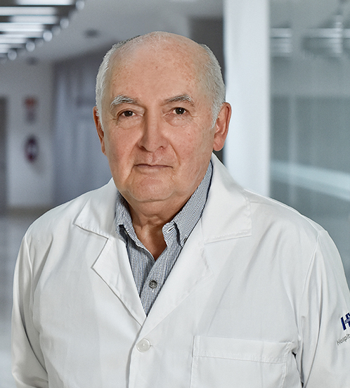 Es la foto de perfil de un oftalmólogo en Huixquilucan de Hospital Angeles Lomas. Usa una bata blanca con camisa. Su cabello es canoso y su tez es blanca.