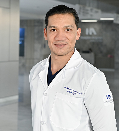 Es la foto de perfil de un oftalmólogo en Querétaro de Hospital Angeles Centro Sur. Viste un traje gris oscuro, con camisa blanca, corbata azul marino, está sonriendo.