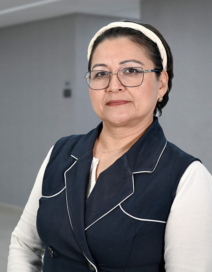 Es la foto de perfil de una psiquiatra infantil en Ciudad de México de Hospital Angeles Lindavista. Tiene el cabello corto negro. Usa lentes, una mascada morada con estampado, una blusa de cuello morado y un sueter negro con estampado.