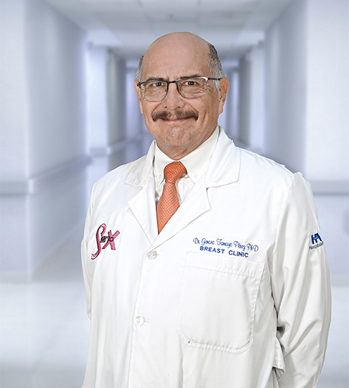 Es la foto de perfil de un cirujano general en Ciudad Juárez de Hospital Angeles Ciudad Juárez. Viste una bata blanca con una camisa blanca y bigote.