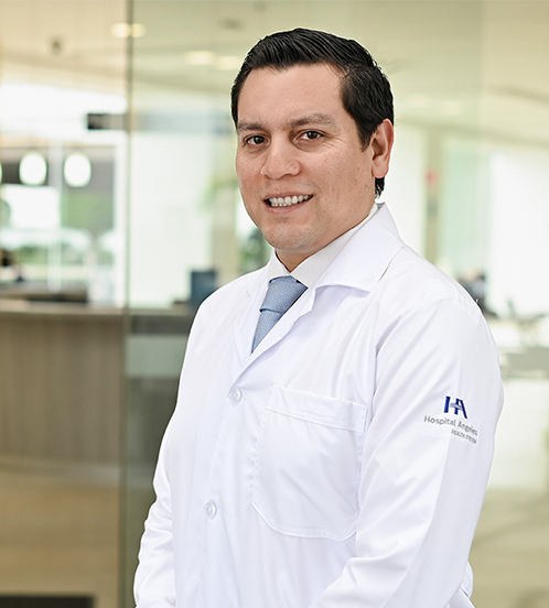 Es la foto de perfil de un cirujano neurológico en Querétaro de Hospital Angeles Centro Sur. Viste una bata blanca con una playera negra.