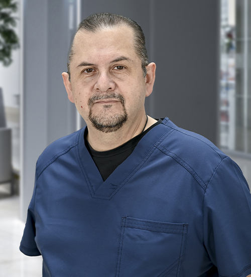 Es la foto de perfil de un anestesiólogo en Ciudad de México de Hospital Angeles. El doctor tiene lentes, barba de candado y viste un uniforme negro. 