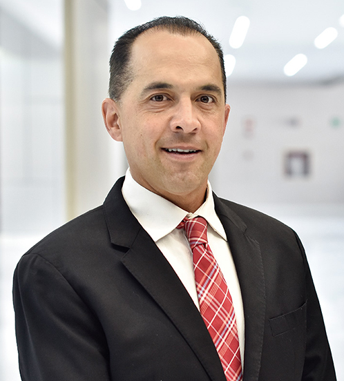 Es la foto de perfil de un biólogo de la reproducción en Querétaro de Hospital Angeles Centro Sur. Viste un traje negro con camisa blanca y corbata roja.