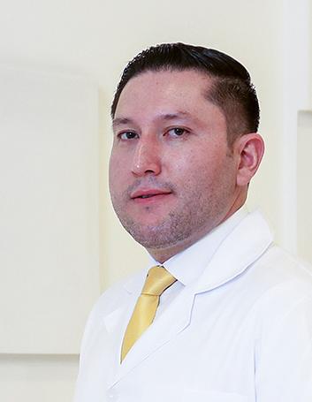 Es la foto de perfil de un neumólogo en León de Hospital Angeles León. Usa una bata blanca con camisa blanca y corbata amarilla.