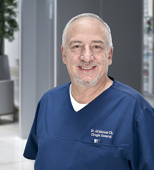 Es la foto de perfil de un cirujano general en Huixquilucan de Hospital Angeles Lomas. Usa un traje negro, con una camisa blanca y una corbata, tiene lentes y el cabello canoso.
