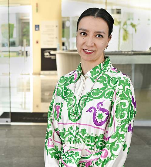 Es la foto de perfil de una oftalmóloga en Ciudad de México de Hospital Angeles Acoxpa. Usa una blusa verde con detalles blancos y morados. Tiene el cabello recogido y la cara levemente inclinada.