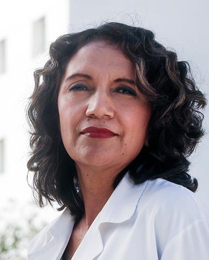 Es la foto de perfil de una nutrióloga en Torreón de Hospital Angeles Torreón. Usa una bata blanca. Tiene el cabello corto y chino color café.