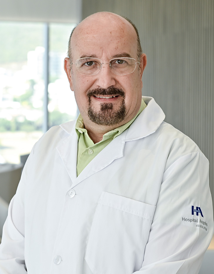 Es la foto de perfil de un internista en San Pedro Garza de Hospital Angeles Valle Oriente. Usa una bata blanca con camisa negra. Tiene la barba gris y usa lentes.