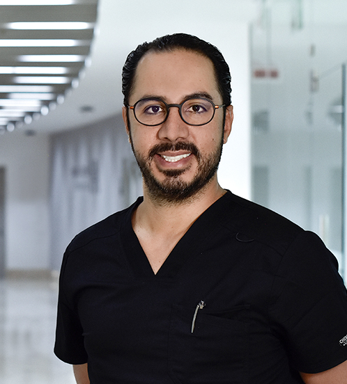 Es la foto de perfil de un endoscopista y cirujano general en Huixquilucan de Hospital Angeles Lomas. El doctor está sonriendo, es de tez morena su cabello es oscuro y tiene barba y bigote oscuro. 
