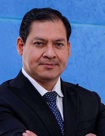 Es la foto de perfil de un coloproctólogo en León de Hospital Angeles León. Usa un saco negro con camisa blanca, tiene una corbata azul marino con puntos blancos.