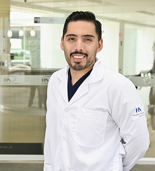 Es la foto de perfil de un ortopedista y traumatólogo en Ciudad de México de Hospital Angeles Acoxpa. Usa una bata blanca con un uniforme médico azul oscuro. Tiene barba y cabello negro.
