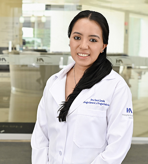 Es la foto de perfil de una cirujana general en Ciudad de México de Hospital Angeles Acoxpa. Usa una bata color blanca, aretes y collar color plata. Tiene el cabello largo y negro.