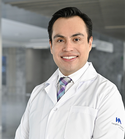 Es la foto de perfil de un cirujano neurológico en Querétaro de Hospital Angeles Centro Sur. Viste un traje azul marino con cuadros y una camisa blanca.