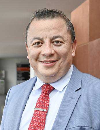 Es la foto de perfil de un urólogo en León de Hospital Angeles León. Viste un saco gris con una camisa blanca y una corbata roja.