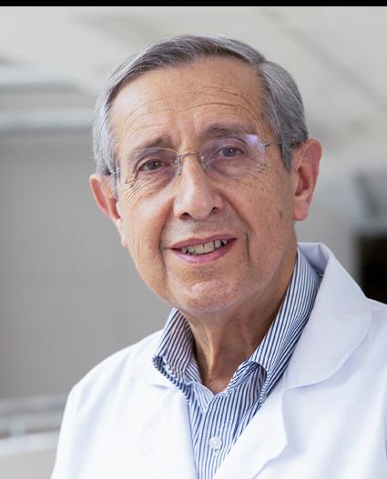 Es la foto de perfil de un reumatólogo en Huixquilucan de Hospital Angeles Lomas. Usa una bata blanca con una camisa, tiene lentes y el cabello canoso.