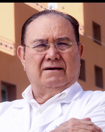 Es la foto de perfil de un cirujano general en Torreón de Hospital Angeles Torreón. Usa una bata y camisa blanca. Tiene el abello negro y usa lentes.