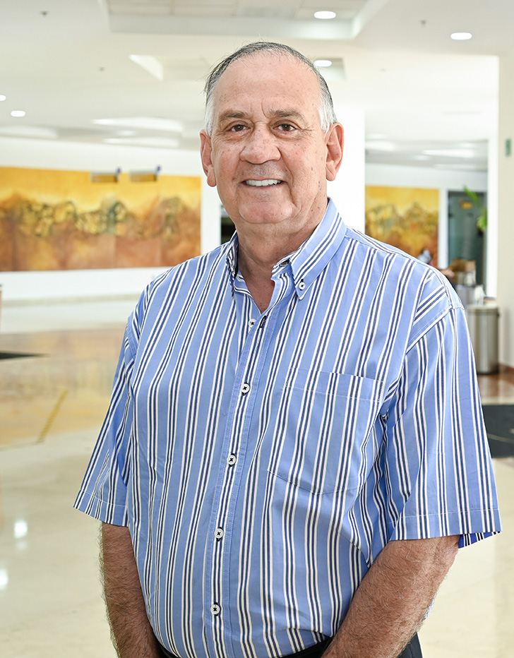 Es la foto de perfil de un ginecólogo y obstetra en Ciudad Juárez de Hospital Angeles Ciudad Juárez. Viste una camisa azul cielo con líneas verticales negras con blanco.