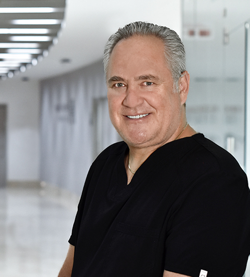 Es la foto de perfil de un pediatra especialista en gastroenterología pediátrica en Huixquilucan de Hospital Angeles Lomas. El doctor usa un unforme negro y está sonriendo. 