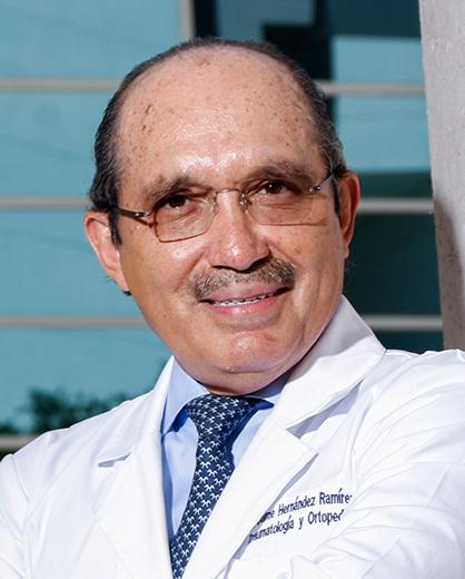 Es la foto de perfil de un ortopedista y traumatólogo en San Pedro Garza de Hospital Angeles Valle Oriente. Usa una bata blanca y una camisa azul claro con una corbata azul. Tiene el cabello negro. Usa lentes.