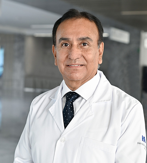 Es la foto de perfil de un urólogo en Querétaro de Hospital Angeles Centro Sur. Usa un traje de cuadros negro, con una camisa blanca y una corbata negra con puntos blancos.