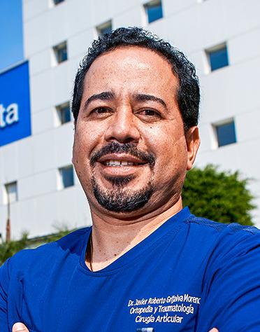 Es la foto de perfil de un ortopedista y traumatólogo en Ciudad de México de Hospital Angeles. El doctor viste un uniforme azul, tiene el cabello rizado y barba candado. Brinda sus servicios en hospital Angeles Acoxpa y Lindavista.